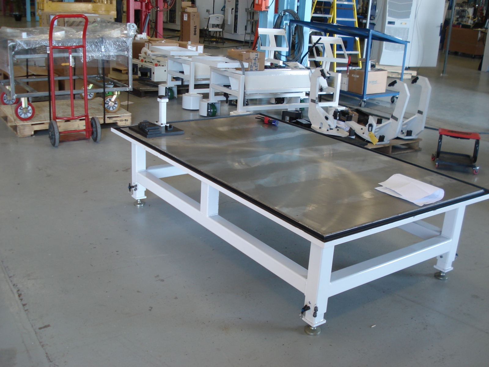 Transmission repair table with adjustable legs and perimeter oil drip trough.